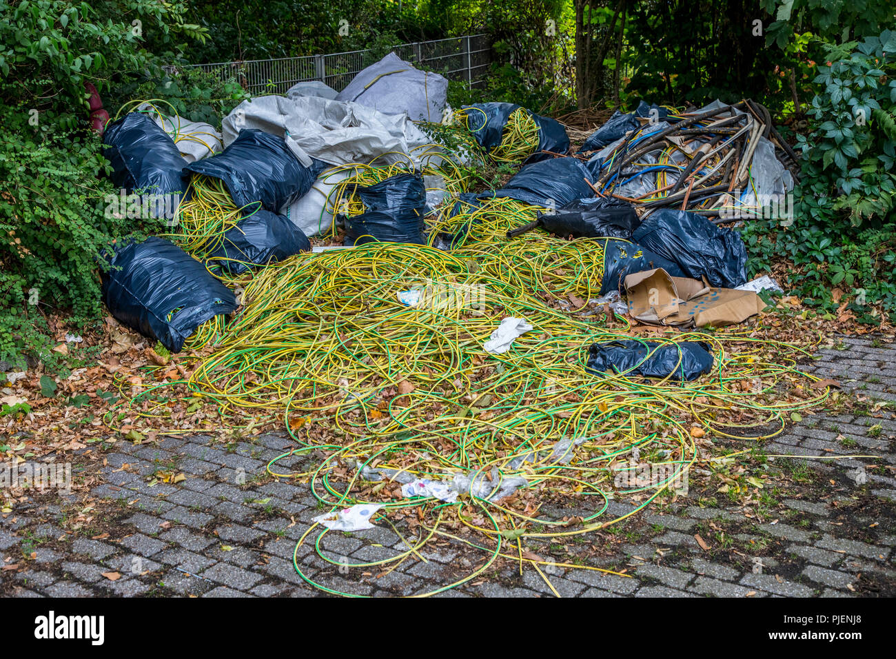 Dépotoir sauvage sur un terrain de stationnement public, l'élimination illégale de déchets de construction, déchets de câbles, à grande échelle, la poubelle a été déposée plus tard f Banque D'Images