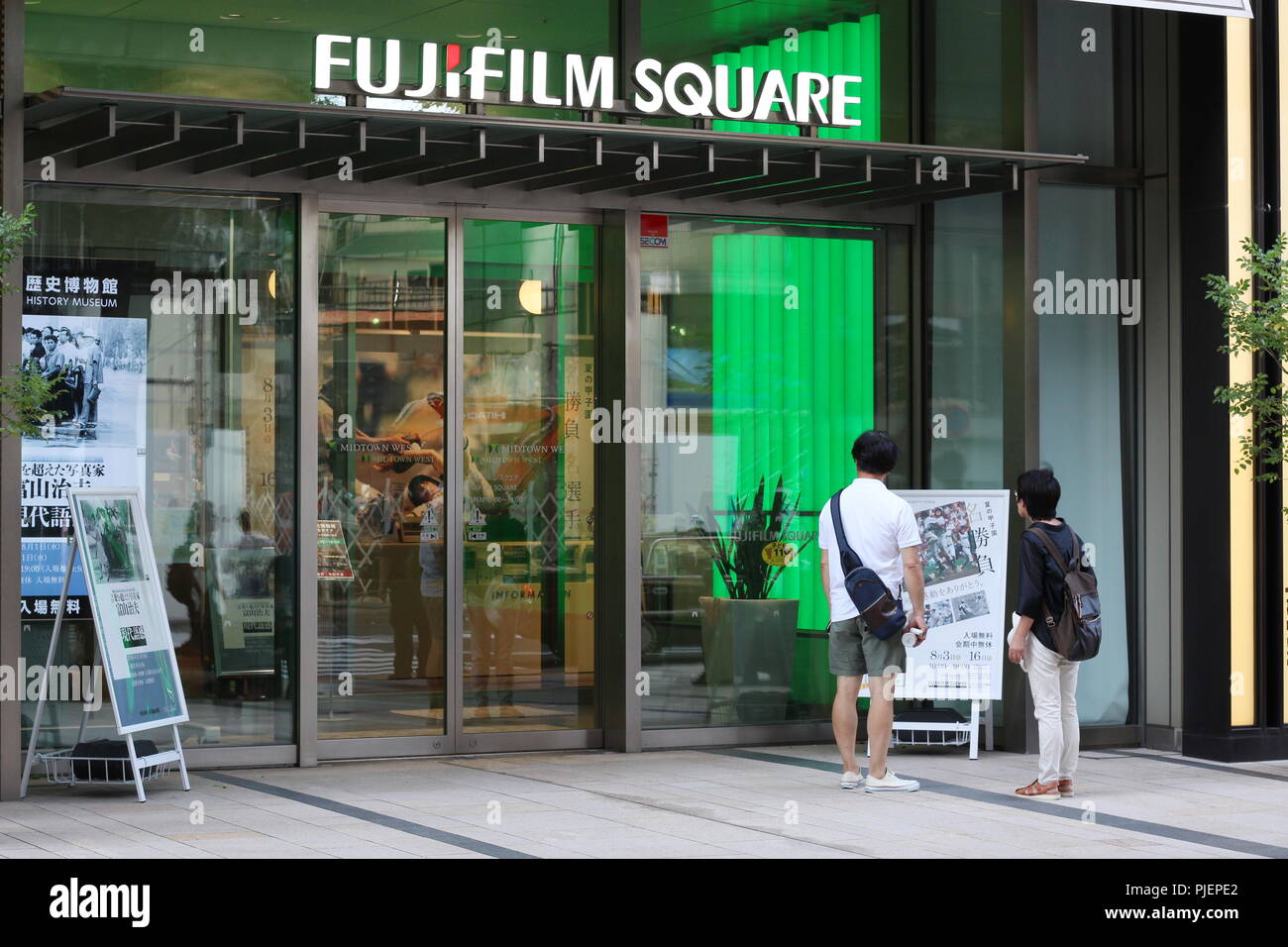 TOKYO, JAPON - 15 août 2018 : les visiteurs regardent un panneau à l'avant de Fuji film Square, une galerie / un musée de l'appareil photo / salle d'exposition située dans le quartier Midtown de Tokyo. Banque D'Images