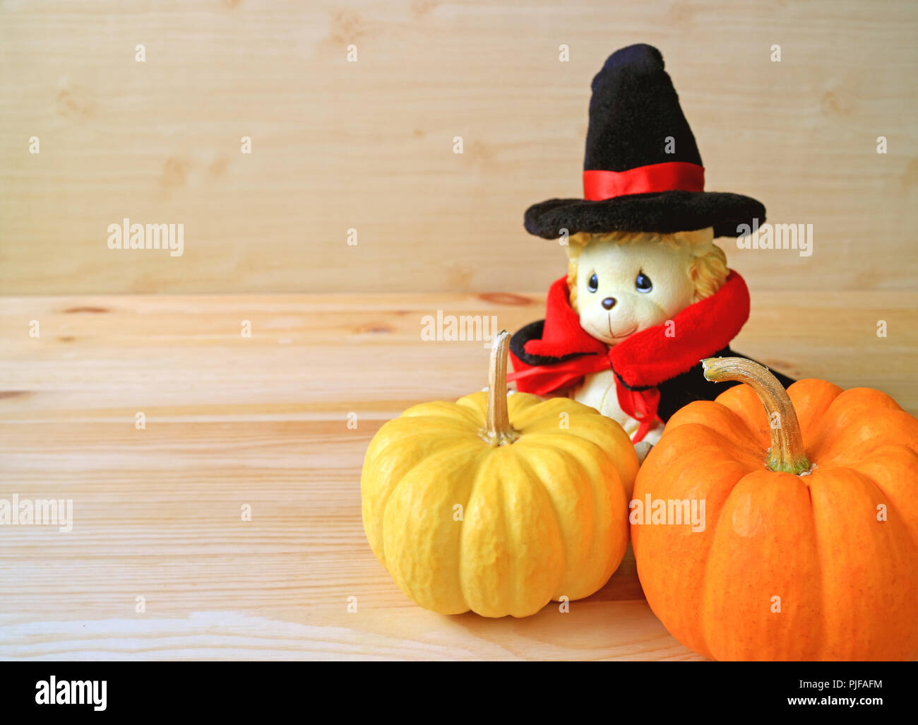 Couleur orange vif, fermée et jaune citrouille mûre avec Lion Adorable Doudou en costume de l'assistant sur fond de bois Banque D'Images