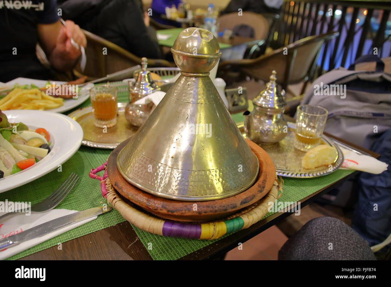 Tajine Marocain Traditionnel Plat Appele En Langue Locale Sur Table De Restaurant A Marrakech Les Plaques Avec D Autres Repas Sa Main Verres Avec Du The Photo Stock Alamy