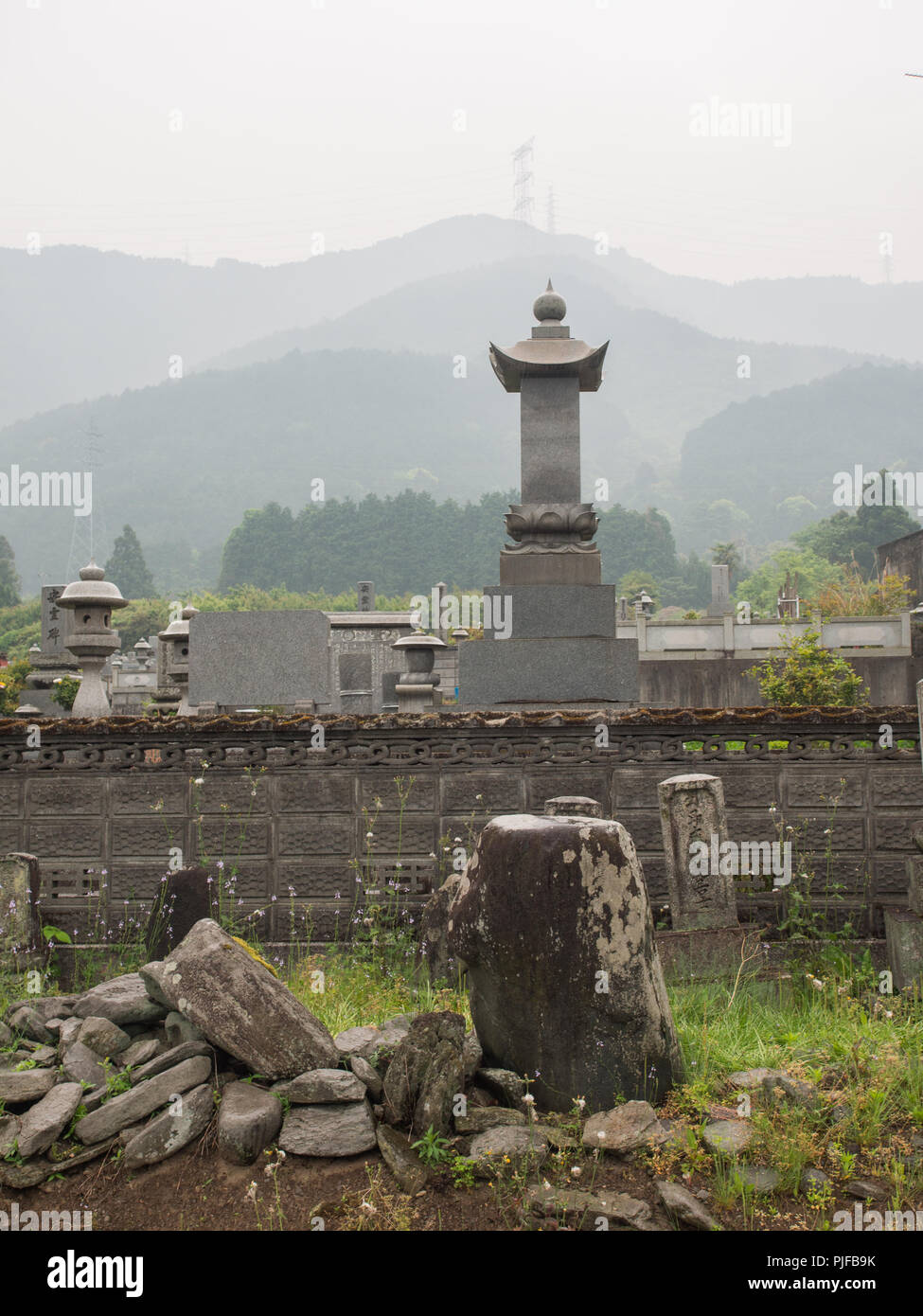 Pierres tombales avec Cemetary, pylônes sur la skyline ridge, Misty day, paysage, Ehime, Shikoku, Japon Banque D'Images