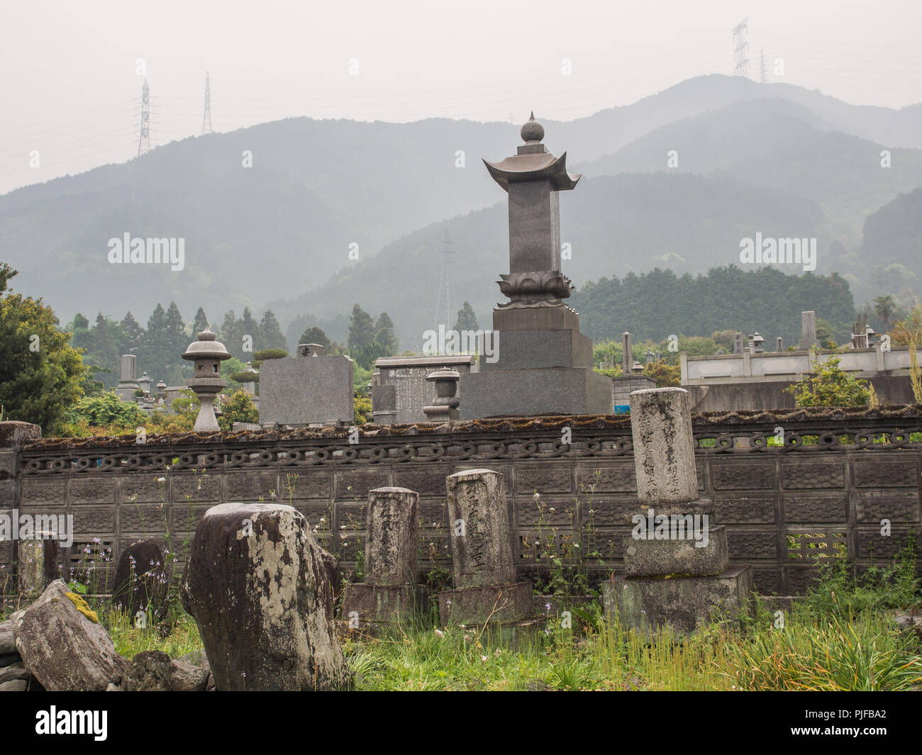 Pierres tombales avec Cemetary, pylônes sur la skyline ridge, Misty day, paysage, Ehime, Shikoku, Japon Banque D'Images