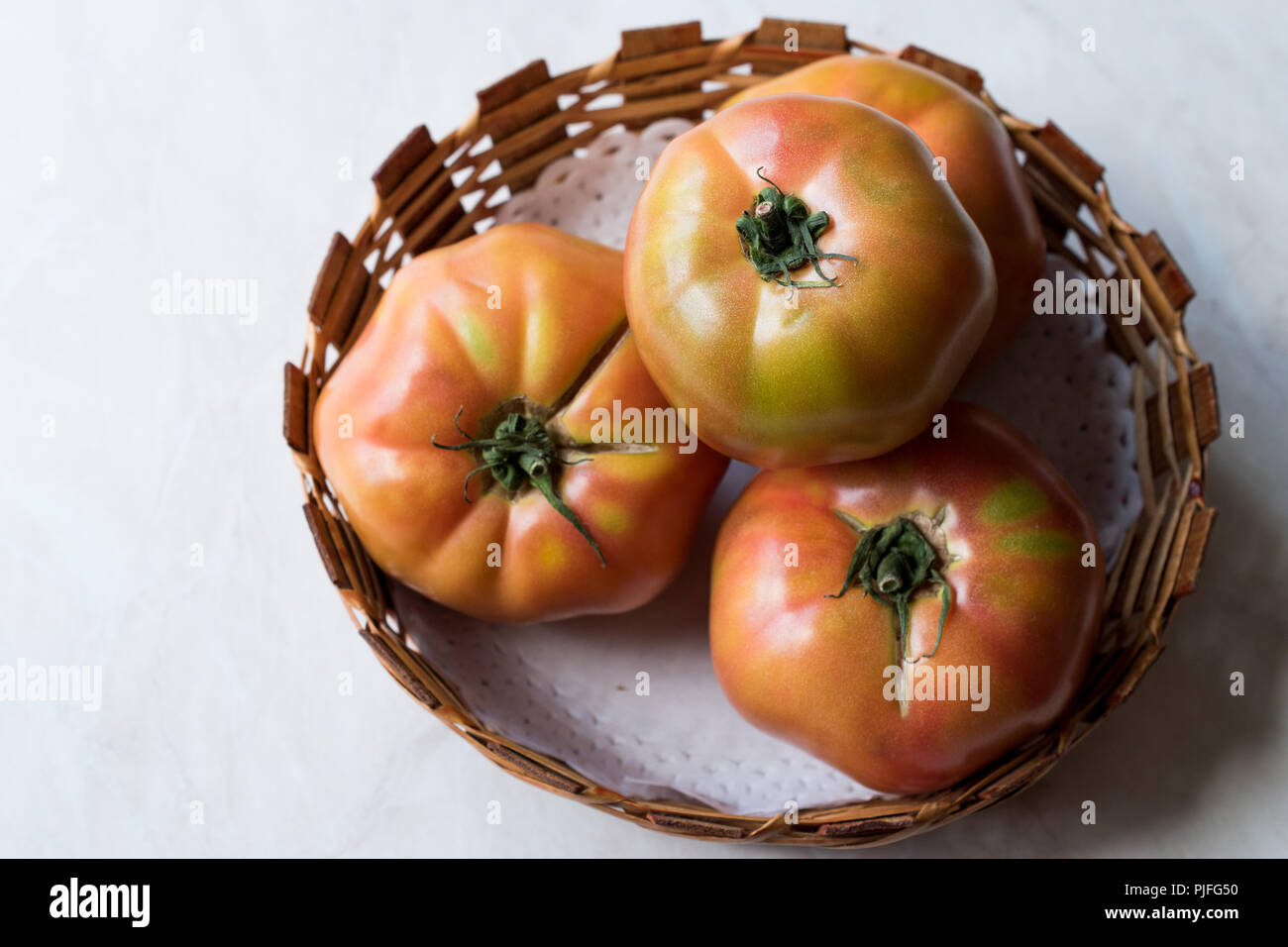 Bio rose Big les tomates dans le panier en bois. L'alimentation biologique. Banque D'Images