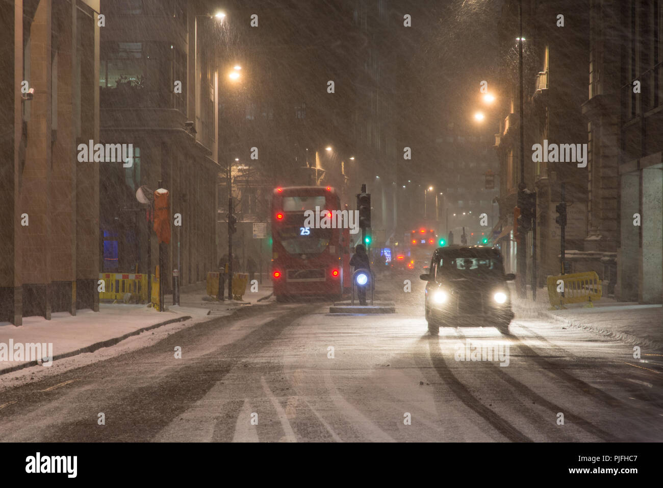 Londres, Angleterre, Royaume-Uni - 28 Février 2018 : trafic crée les sentiers dans la neige qui tombe sur Newgate Street au cours de la 'bête de l'Est' tempête dans l'EC Banque D'Images
