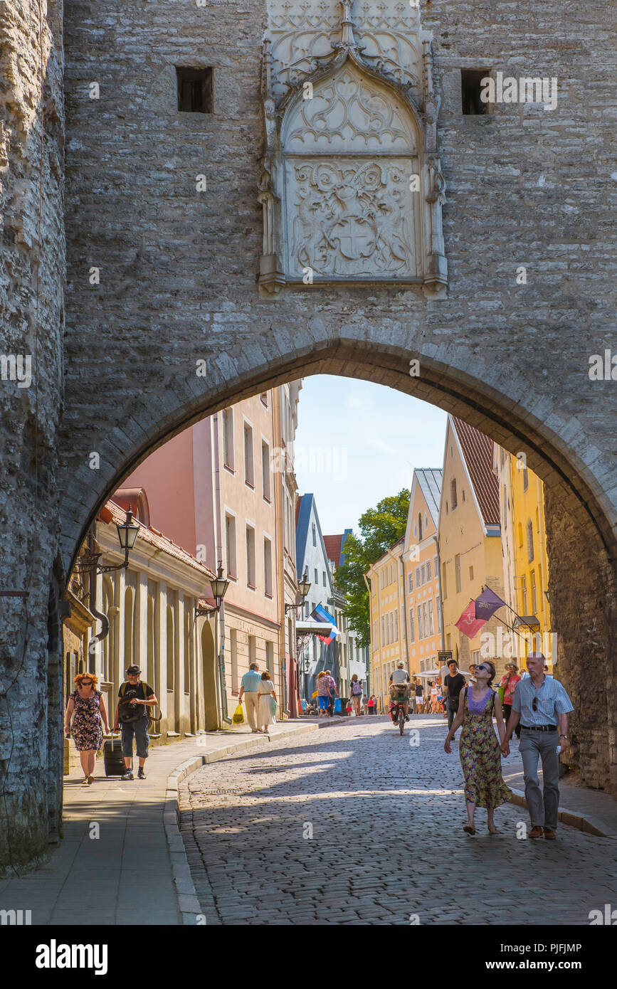 Voir des gens marcher sous la voûte de la grande porte de la côte sur la rue Pikk sur le côté nord de la vieille ville médiévale de Tallinn, Estonie. Banque D'Images
