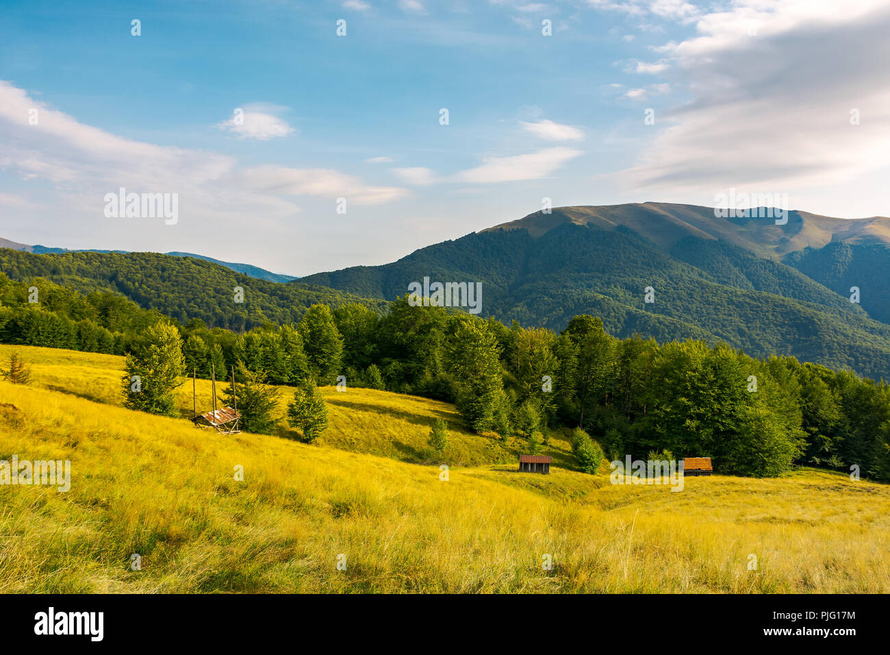 Campagne dans les montagnes. beau paysage et les collines herbeuses. abandonné alpine bûcher et hay barrack sur le pré. crête de montagne dans l'isolation partiellechauffage Banque D'Images