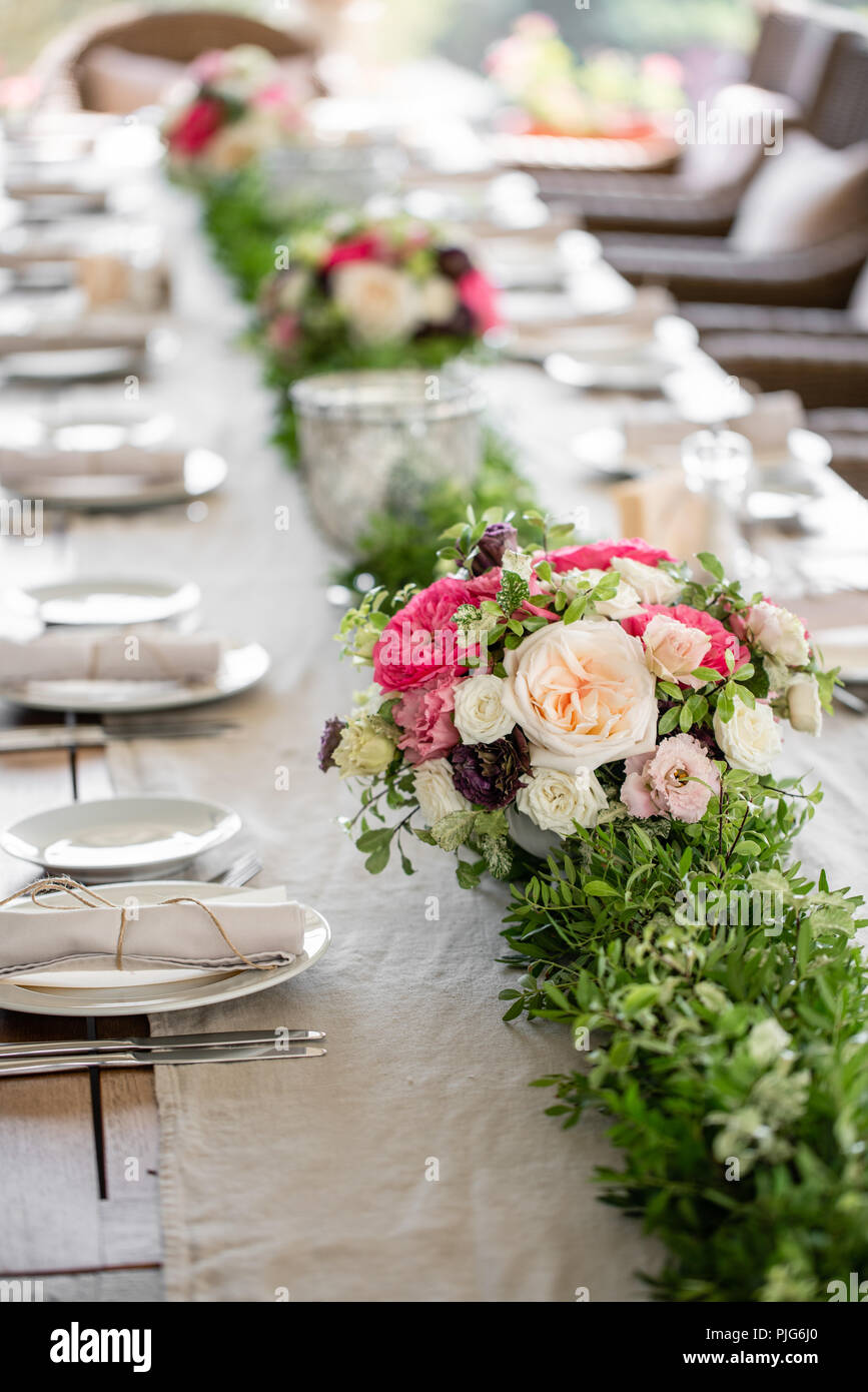 Le banquet de mariage ou un dîner de gala. Les chaises et la table pour les invités, servis avec des couverts et de la vaisselle. Recouverte d'une nappe en lin runner. partie sur terrasse Banque D'Images