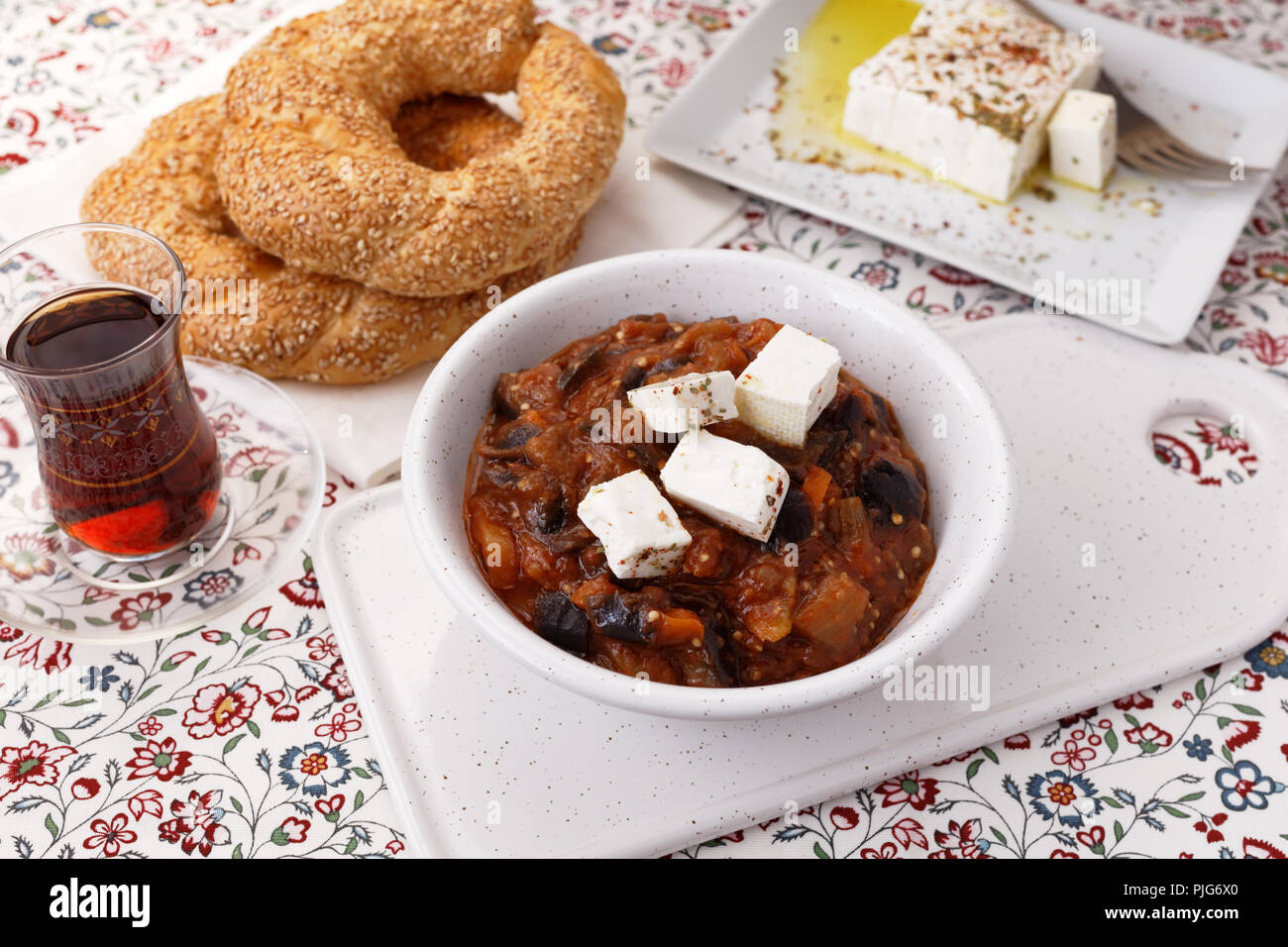 L'aubergine et le poivre ragoût avec de la feta, du thé turc et Turc bagels simits Banque D'Images