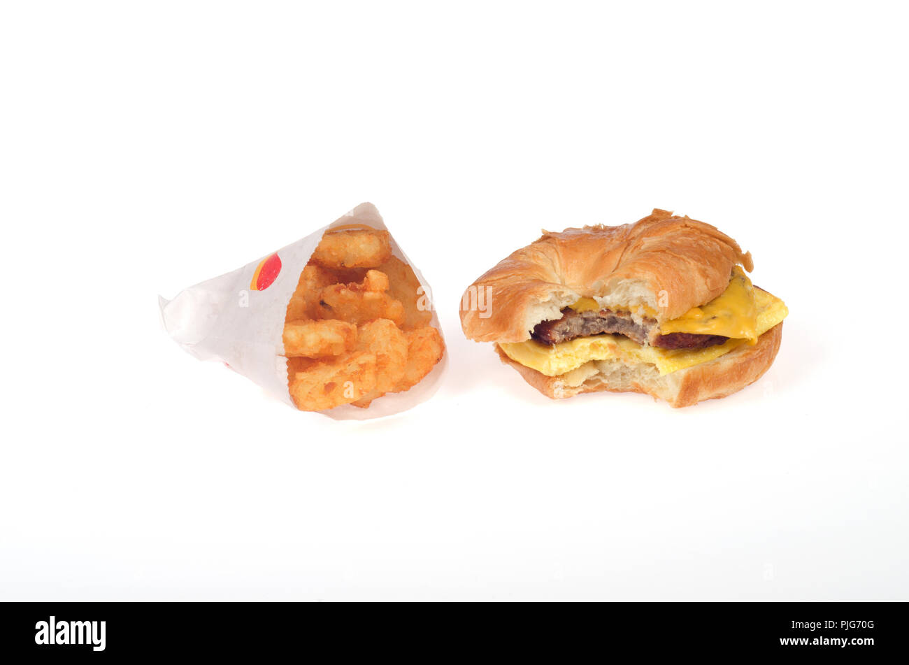 Burger King saucisse, œuf et fromage CROISSAN'WICH ou le croissant sandwich avec paquet paillasson de pommes de terre Banque D'Images