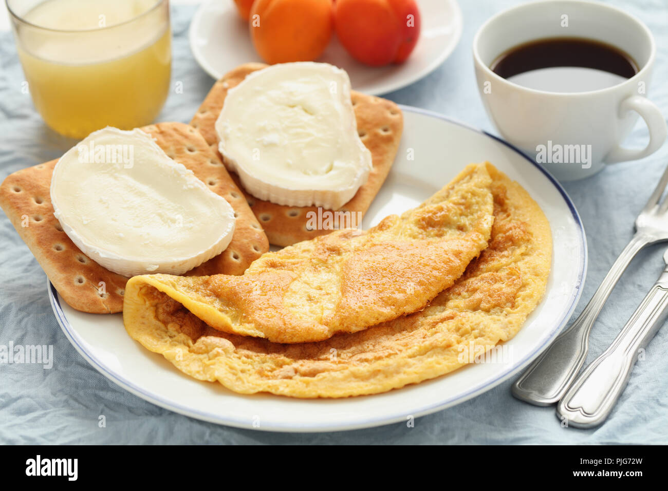 Petit-déjeuner avec omelette française, fromage de chèvre, café noir et abricot Banque D'Images