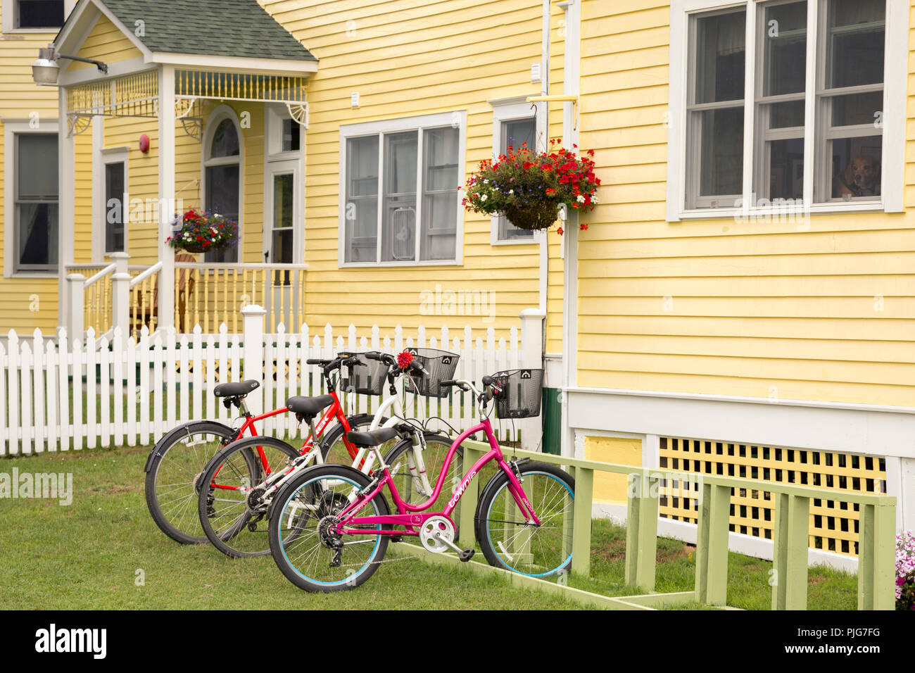 Bicyclettes garées en face d'une charmante maison jaune, sont la principale forme de transport sur l'île Mackinac. C'est un lieu de vacances populaire au Michigan. Banque D'Images