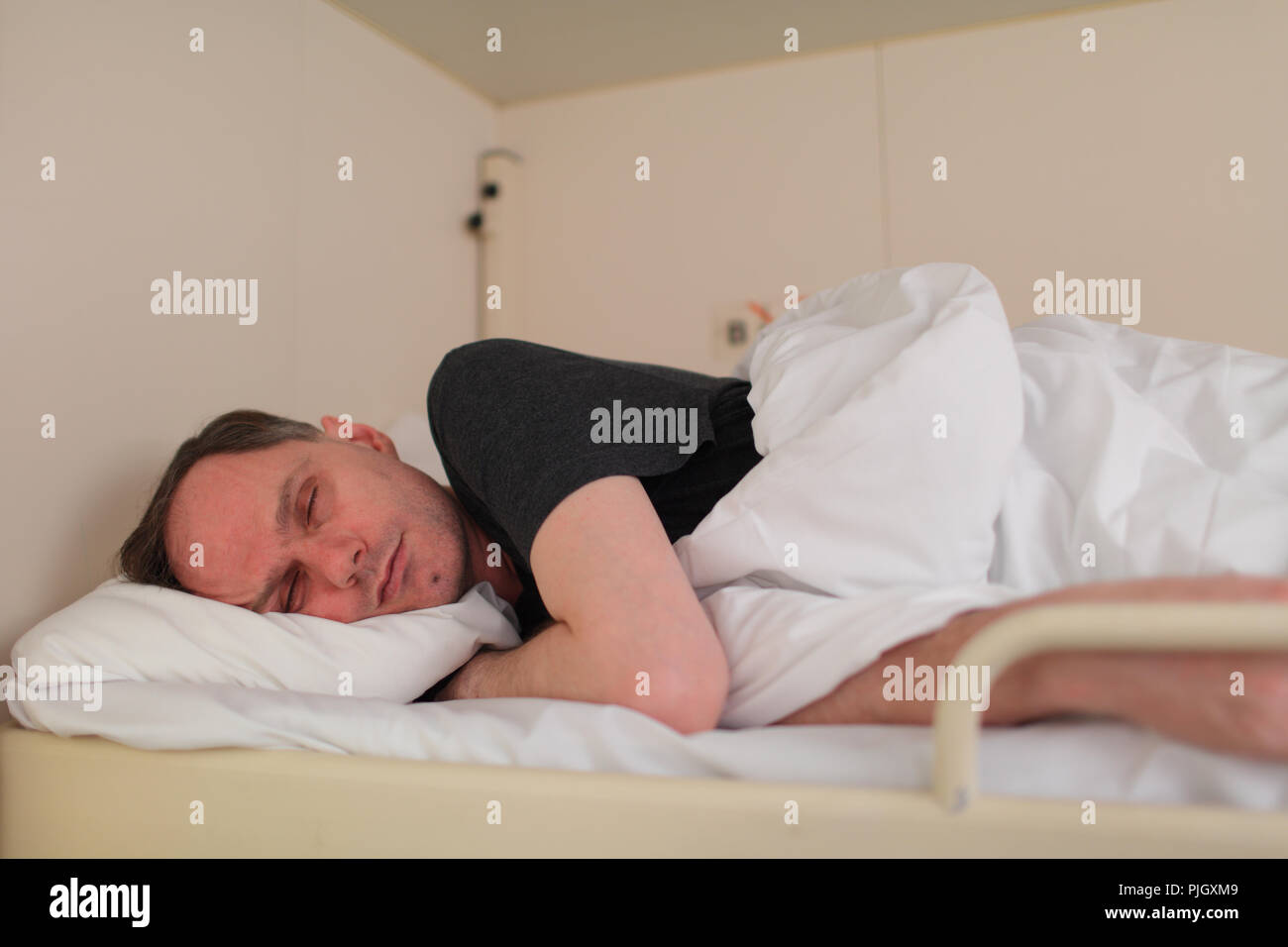 Man sleeping on couchette supérieure dans une cabine d'un navire de croisière Banque D'Images