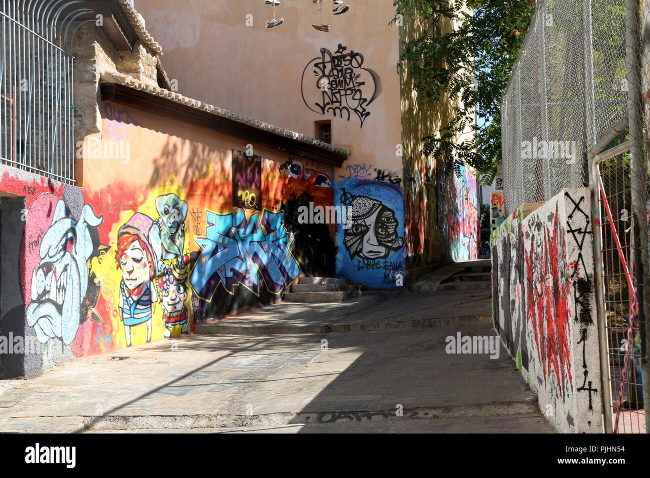 Plaka Athènes Grèce Scène de rue graffitis sur les murs des bâtiments et des chaussures haute suspendus sur le fil Banque D'Images