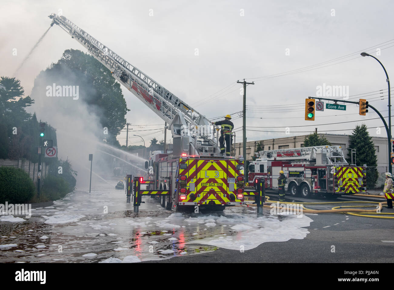 Le personnel d'urgence de camions de pompiers et les hommes du feu sur la scène de l'incendie de la ville de Vancouver. Banque D'Images