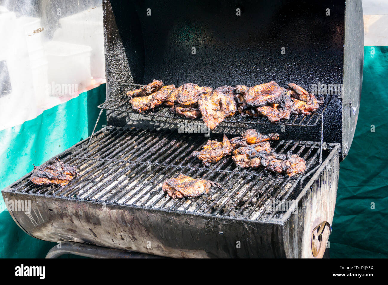 Poulet Jerk cuisson sur un barbecue à un streetfood du sud de Londres, WC séparés. Banque D'Images
