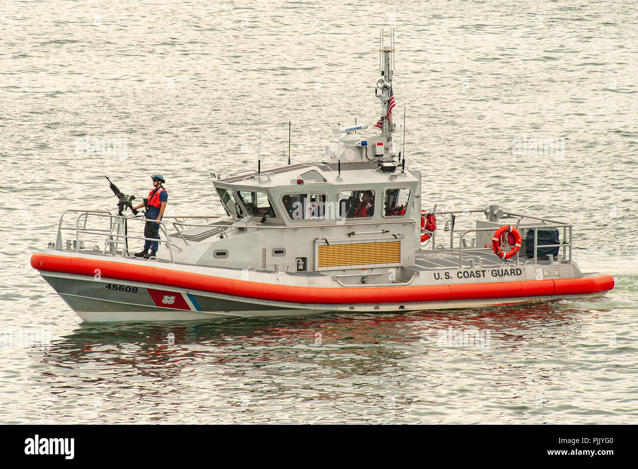 Bateau de la Garde côtière des États-Unis - un membre de l'US Coast Guard mans un fusil sur son bateau d'escorte d'un navire de croisière dans le port de Boston USA - Boston Banque D'Images