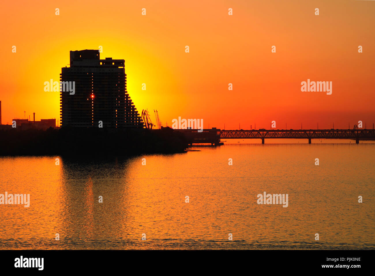 Silhouette d'un gratte-ciel et le pont sur l'orange fond coucher de soleil, sur le Dniepr dans le Dniepr Dniepropetrovsk (ville, Dnepr), Ukraine Banque D'Images