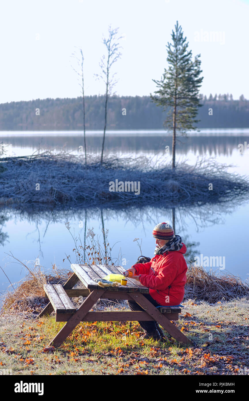 Femme d'âge moyen de prendre une pause-café un jour d'automne froid en Suède Banque D'Images