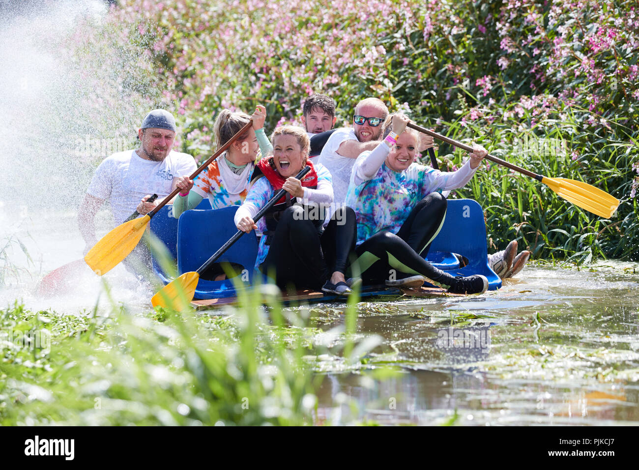 People rowing un radeau le long d'une rivière et se mettre à l'eau à la Plaine des jeux, Thorney, Somerset, Angleterre Banque D'Images