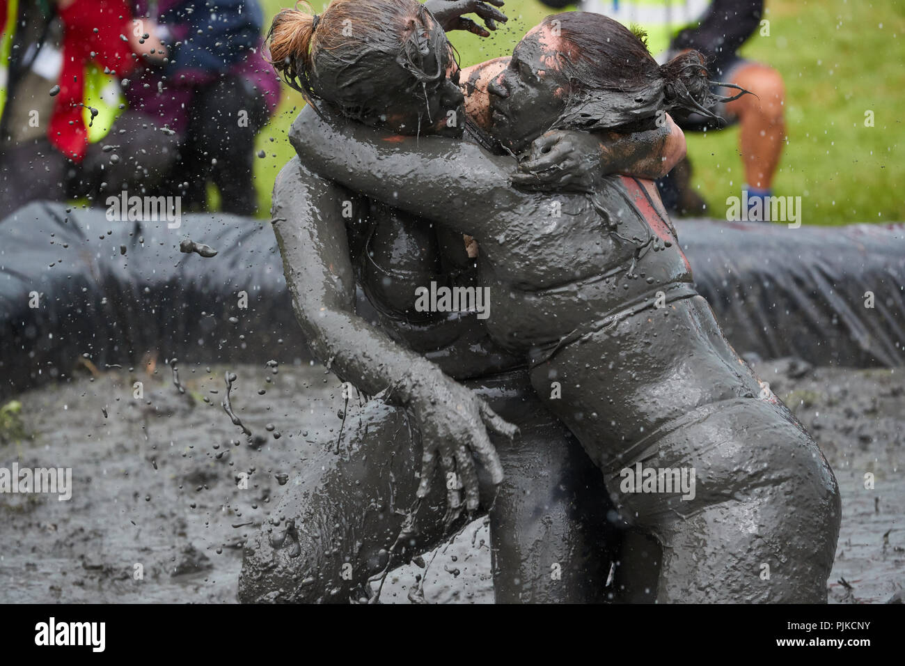 Deux femmes aux prises avec de la boue à la Plaine des jeux, Thorney, Somerset, Angleterre Banque D'Images