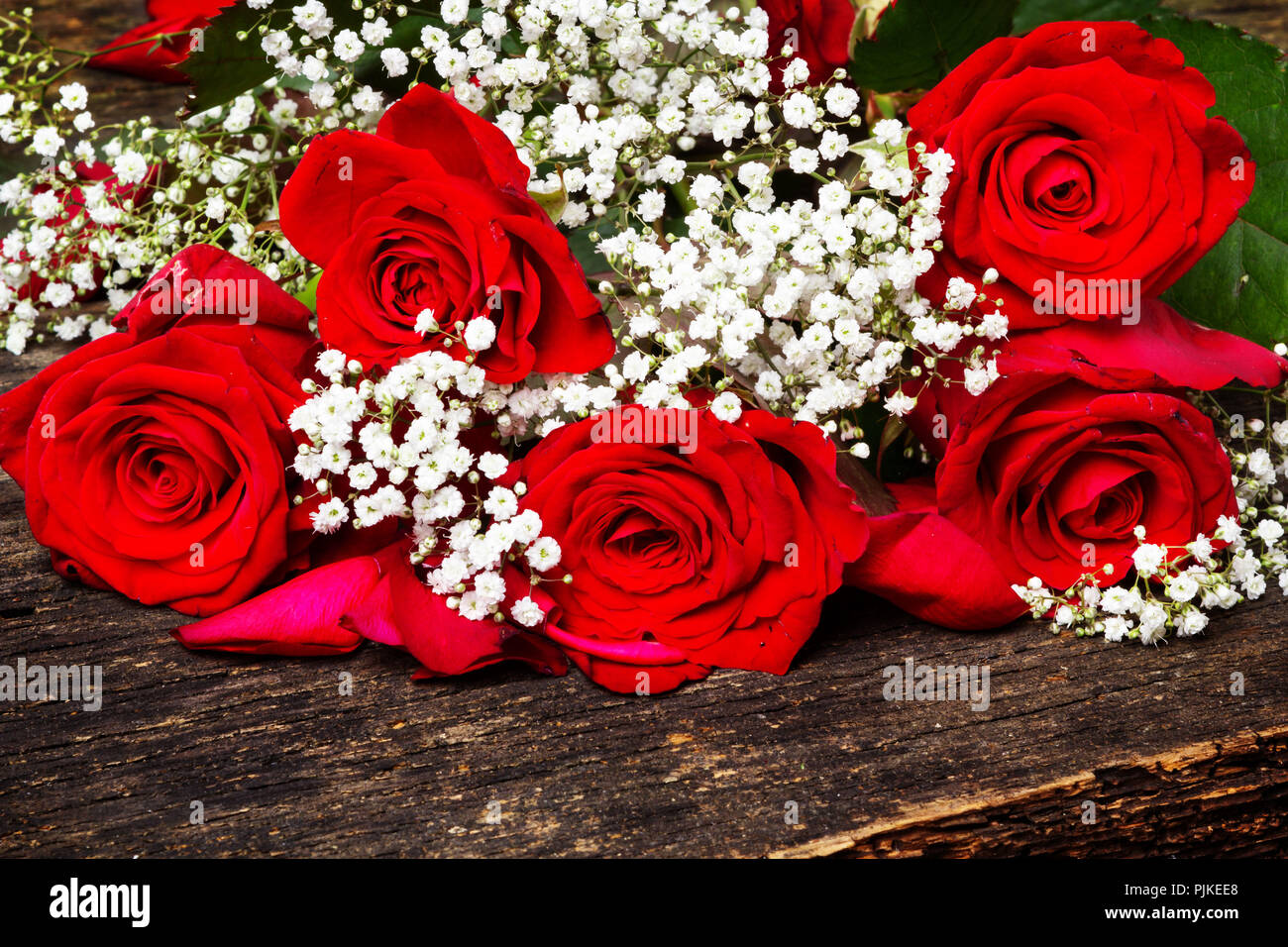 Roses rouges avec gypsophila sur bois Banque D'Images