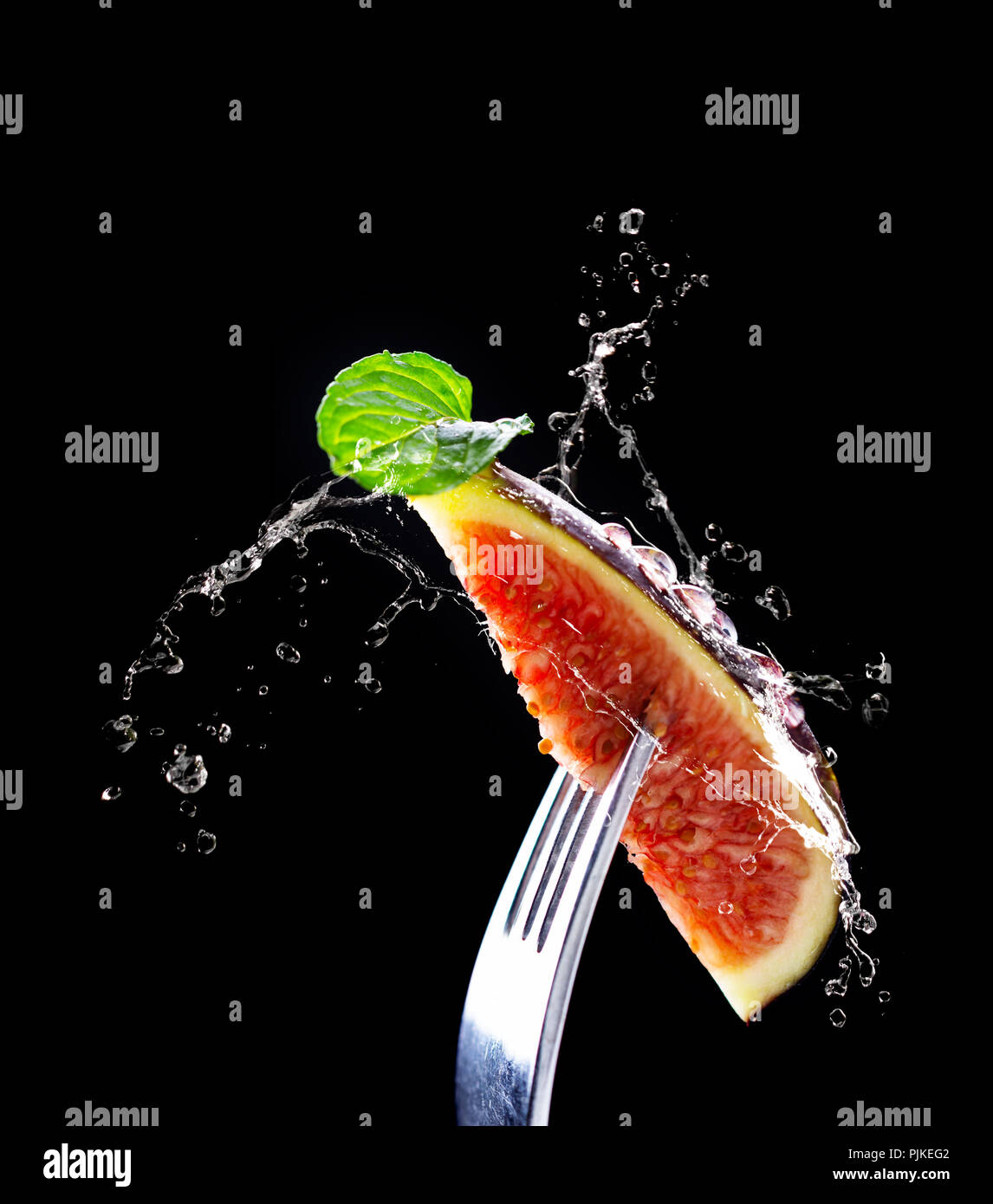 Tranches frais ? ?fig avec feuille de menthe et les projections d'eau sur fourche Banque D'Images