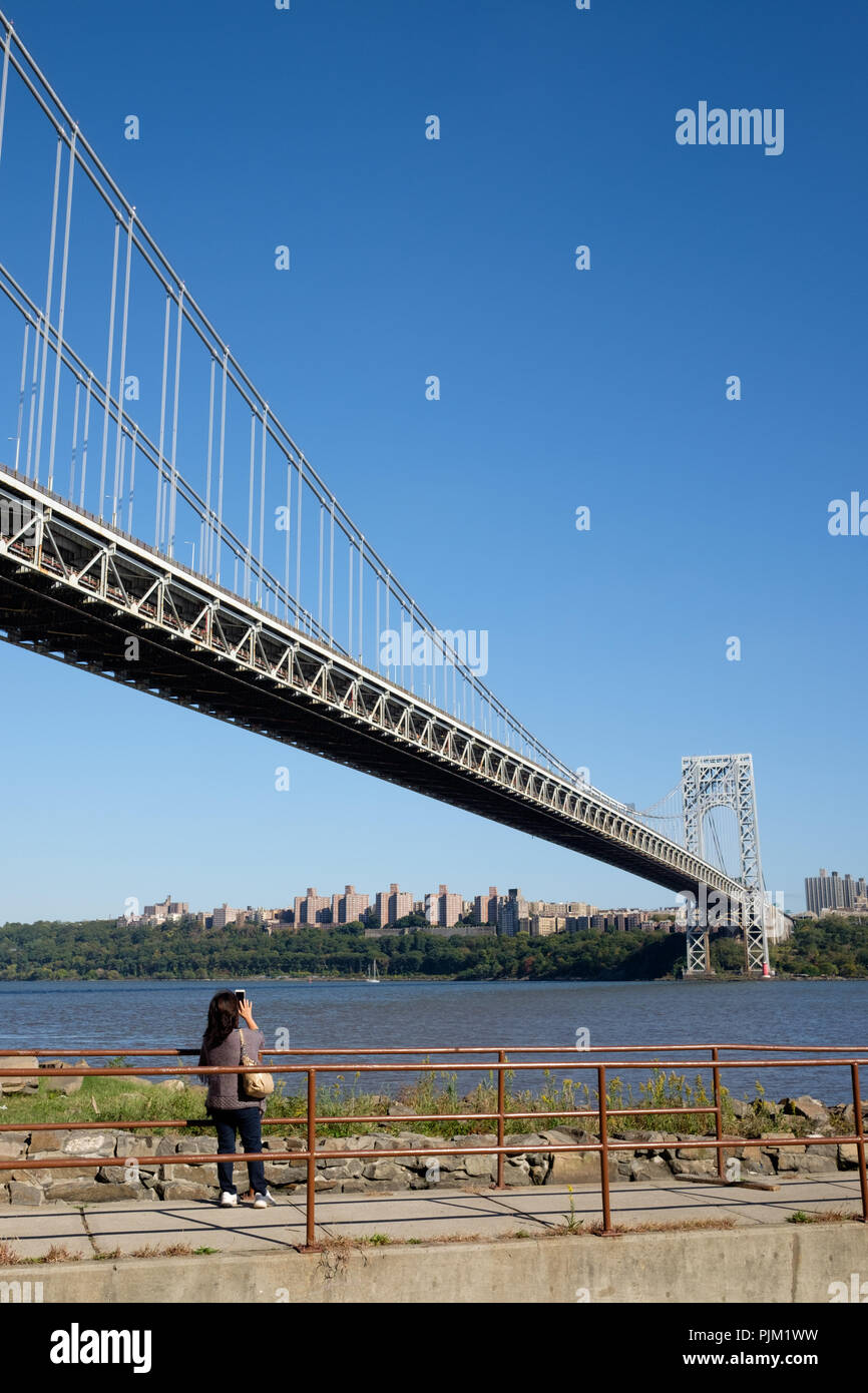 Un touriste prend une photo de la George Washington Bridge à partir de Fort Lee, NJ avec la rivière Hudson, Little Red Phare et la ville de New York. Banque D'Images