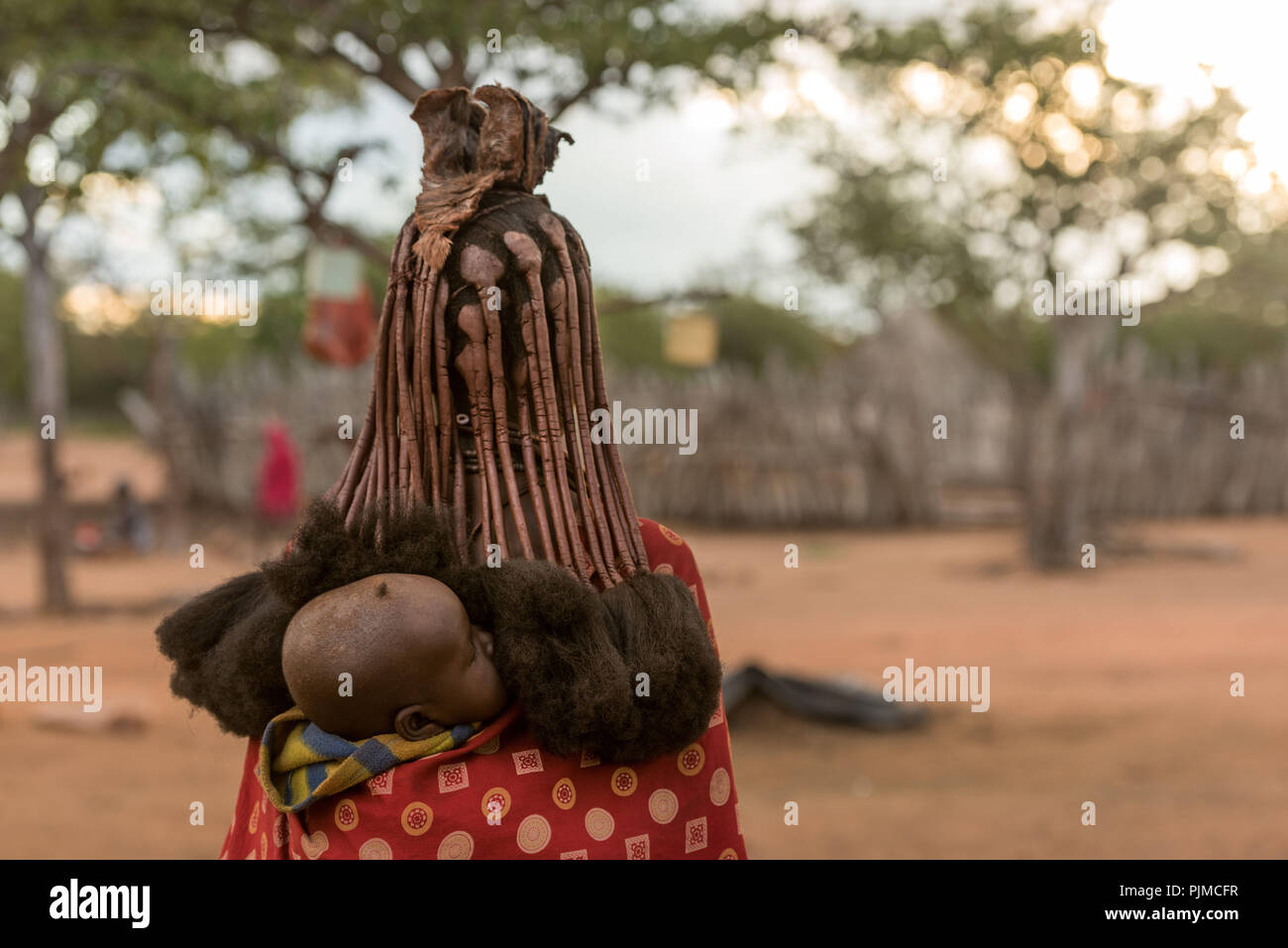 Bébé Himba est porté par sa mère sur son dos, vue arrière Banque D'Images