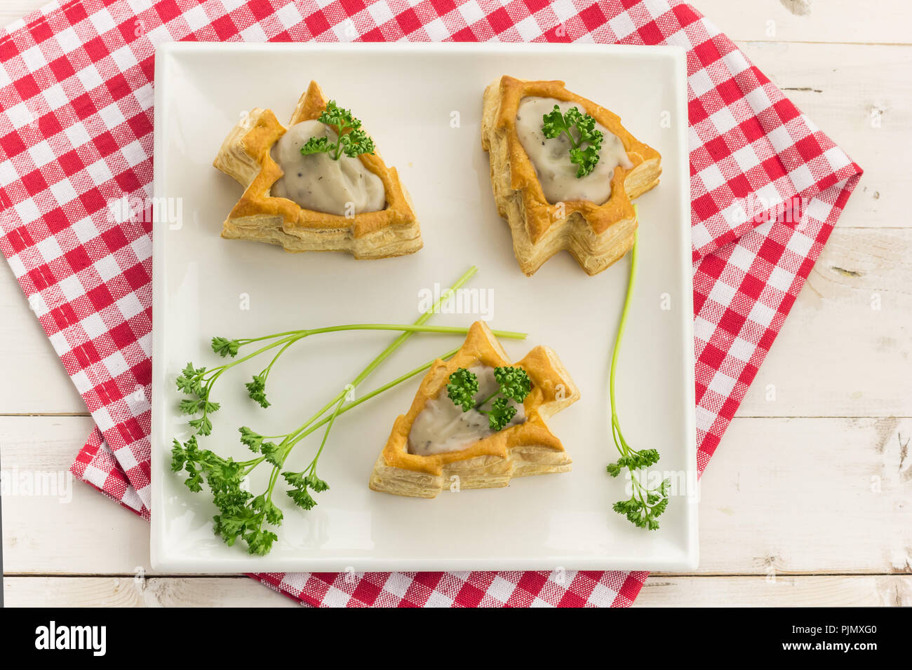 Vol-au-vents en forme d'arbre de Noël, rempli de ragoût de champignons et surmontée de persil frais Banque D'Images