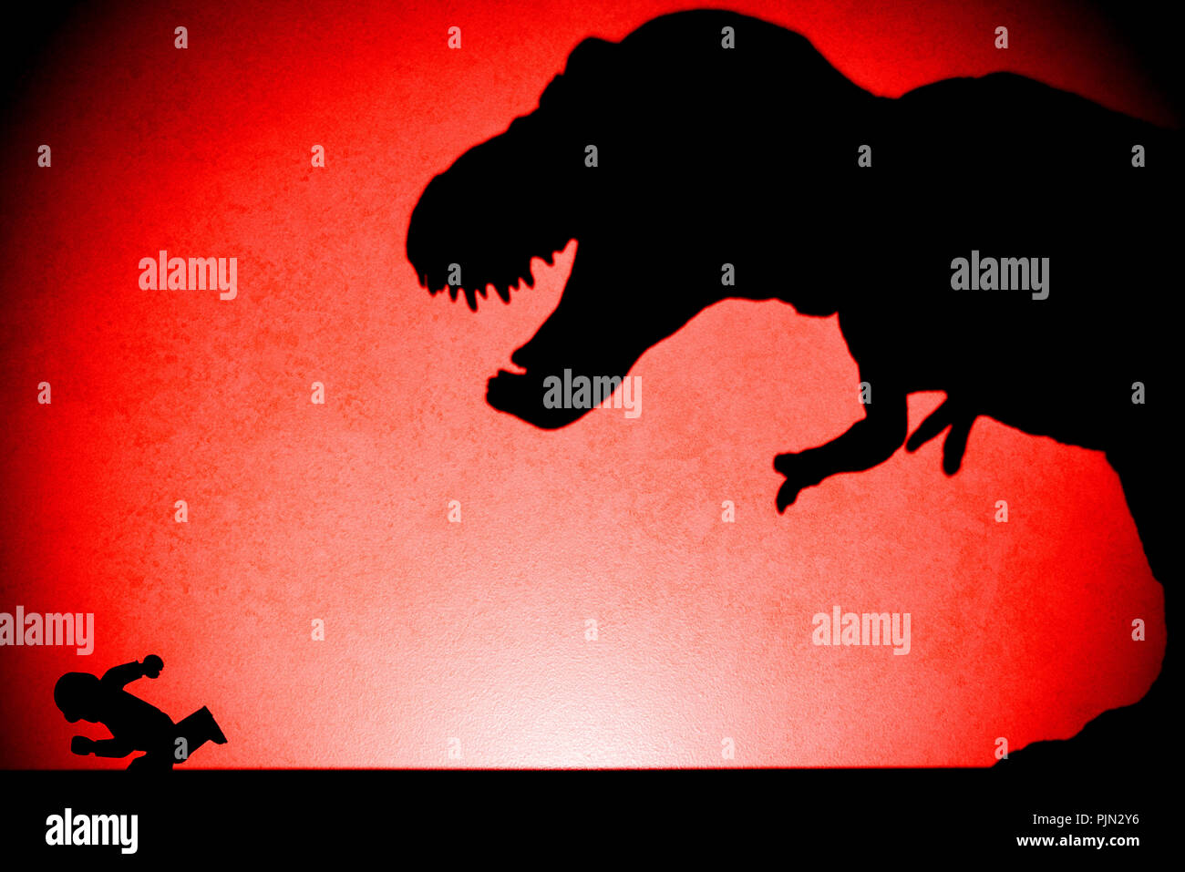 Tache rouge ombre légère de tyrannosaurus chassant sur le mur humain aucun logo ou marque déposée Banque D'Images