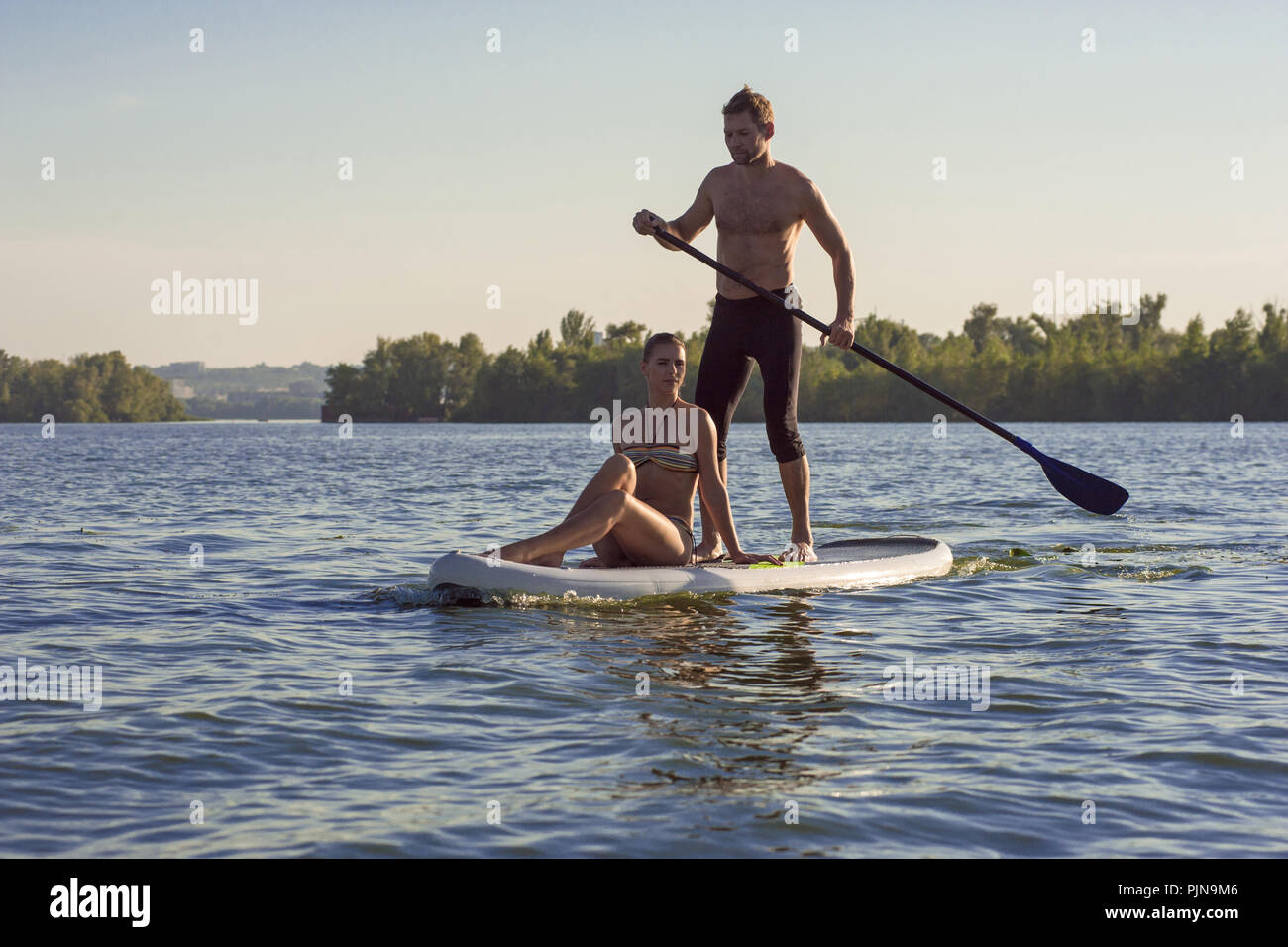 Sports l'homme et la femme en vacances sport sur stand up paddle board SUP Jeunes mariés Banque D'Images