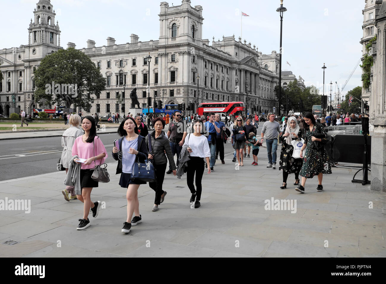 Les touristes se promener dans la rue devant les Chambres du Parlement à Westminster, Londres SW1 England UK KATHY DEWITT Banque D'Images