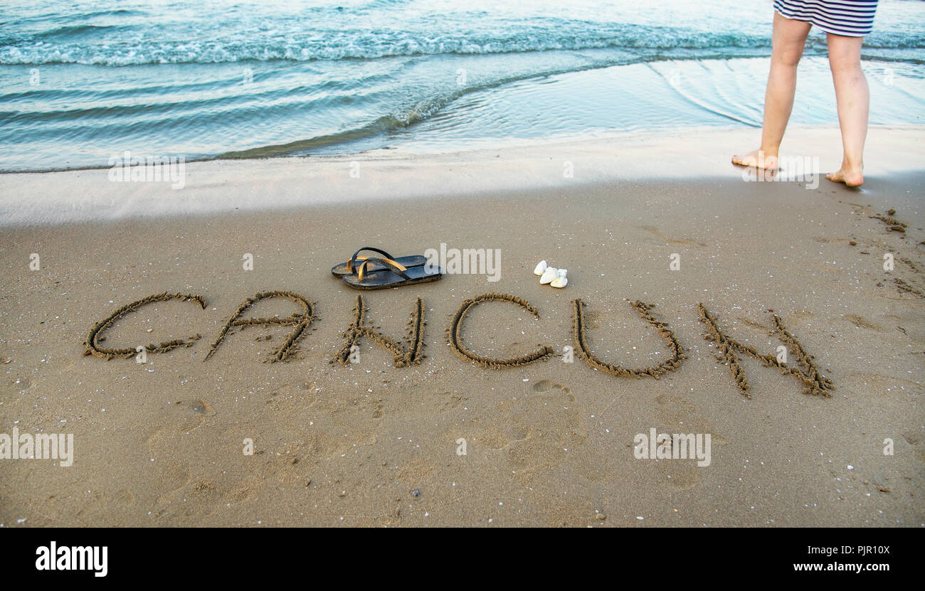 Le mot Cancun écrit dans le sable sur la plage. Locations de concept Banque D'Images