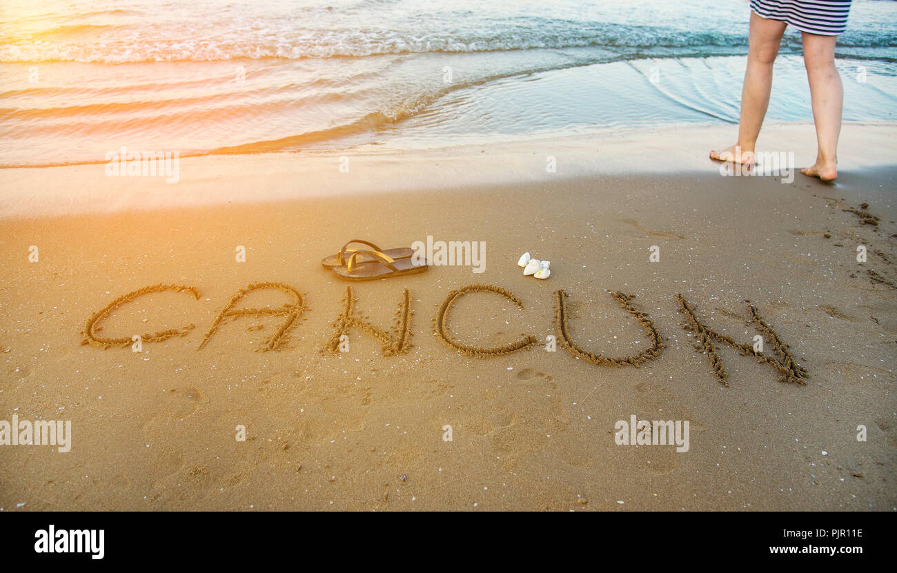 Le mot Cancun écrit dans le sable sur la plage. Locations de concept Banque D'Images