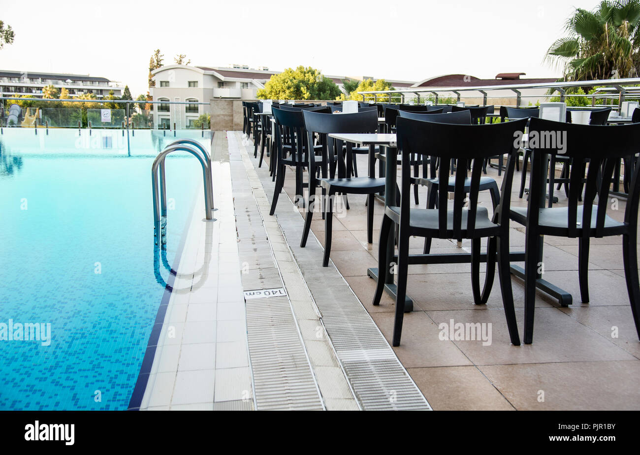 Chaises et tables à côté d'une piscine. Concept de vacances de luxe Banque D'Images