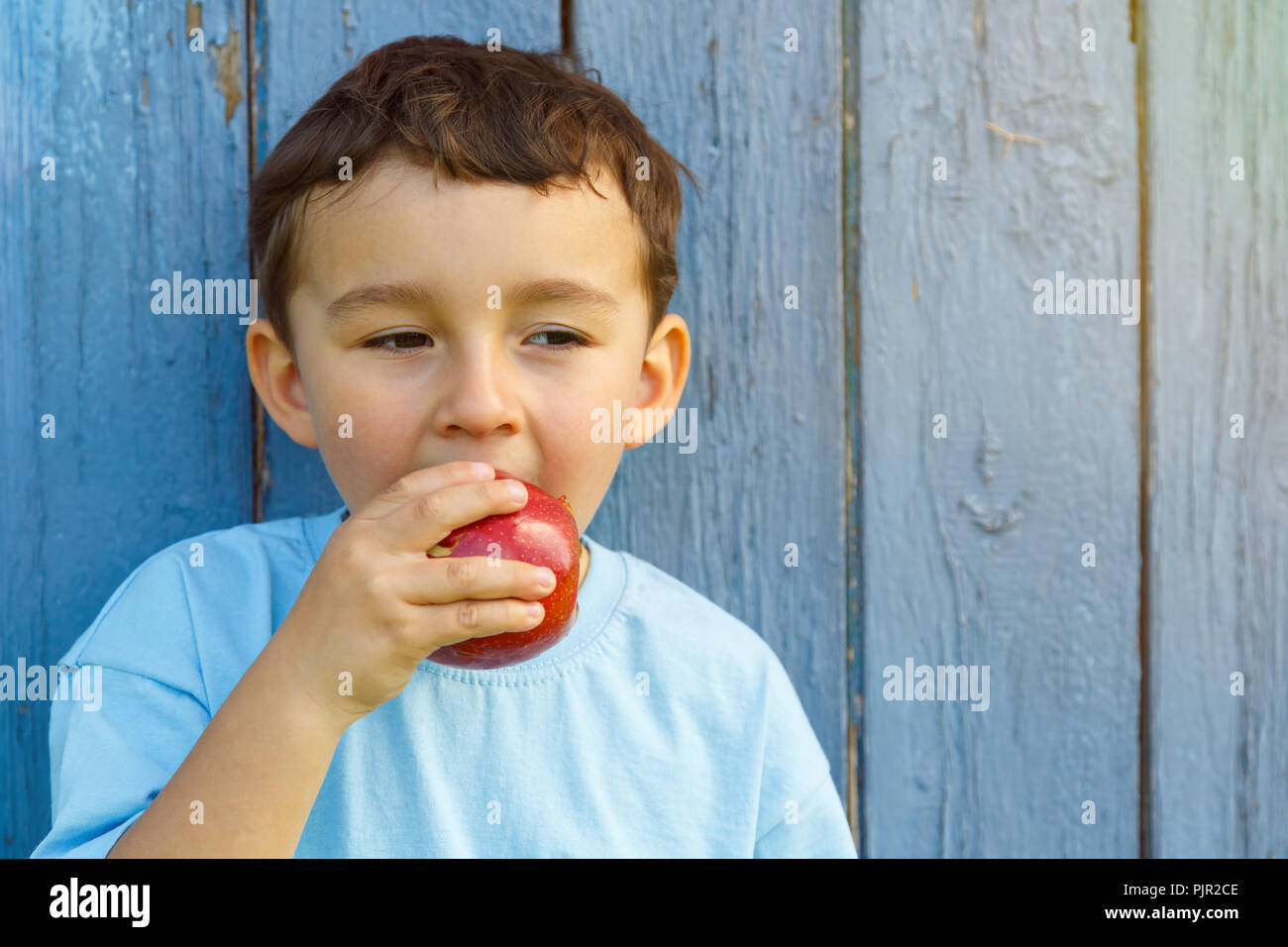 Pomme fruit manger manger enfant petit garçon copyspace copie espace piscine en plein air à l'extérieur de mordre Banque D'Images