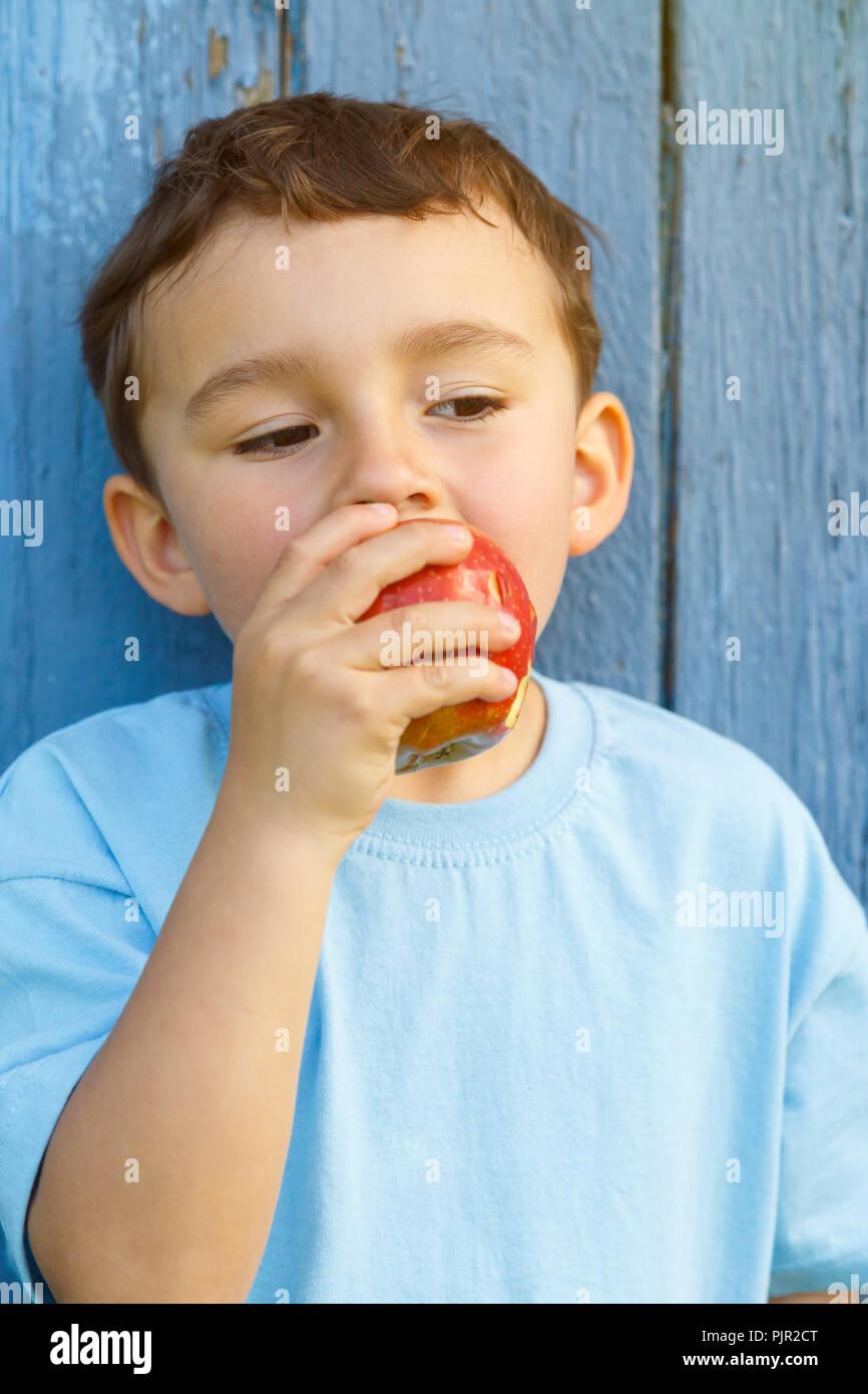 Pomme fruit manger manger enfant petit garçon portrait format plein air à l'extérieur de mordre Banque D'Images