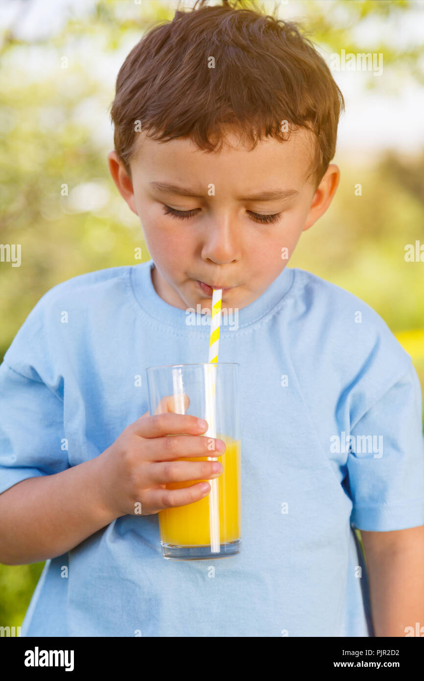 Enfant petit garçon de boire un verre de jus d'orange format portrait printemps en plein air à l'extérieur l'extérieur verre Banque D'Images