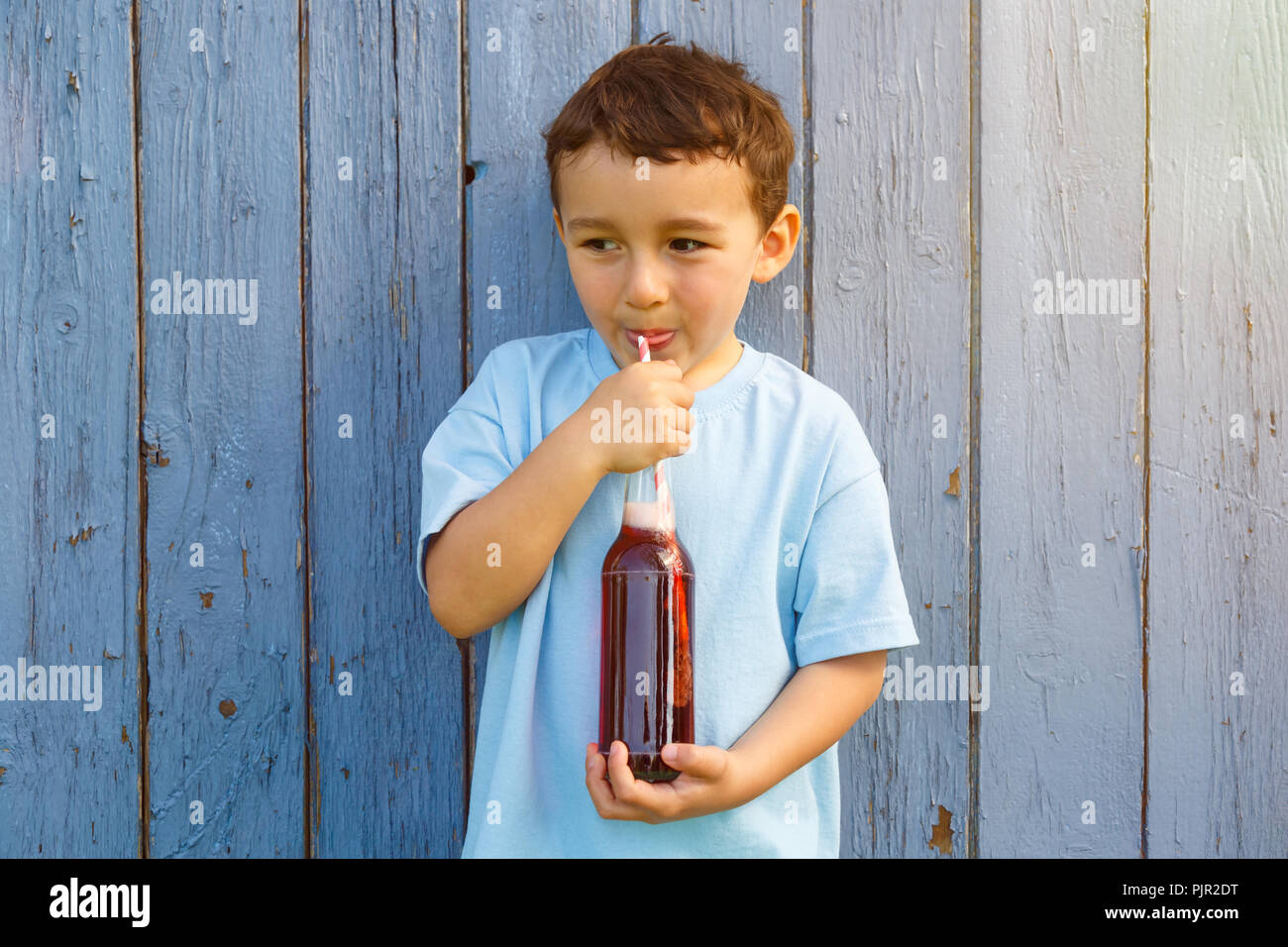 Enfant kid little boy drinking cola boisson limonade copyspace copie espace piscine en plein air à l'extérieur de bouteille Banque D'Images