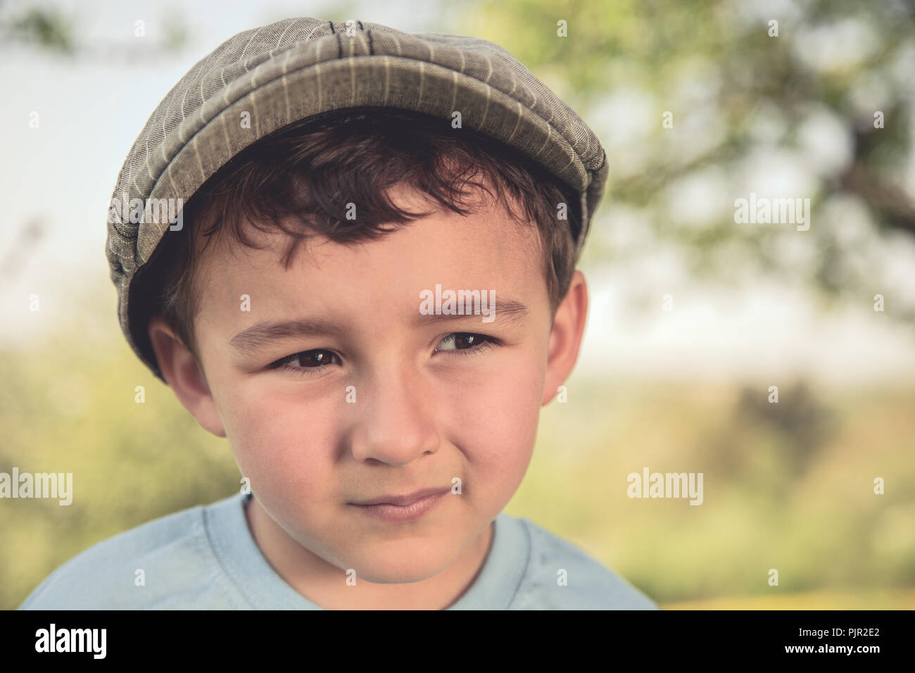 Enfant petit garçon portrait rétro de plein air à la recherche sur le côté à l'aide de la nature Banque D'Images