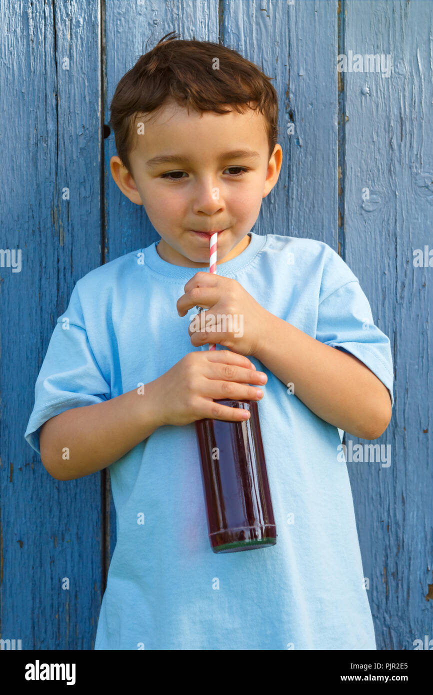 Enfant kid little boy drinking cola boisson limonade format portrait en extérieur extérieur extérieur bouteille Banque D'Images
