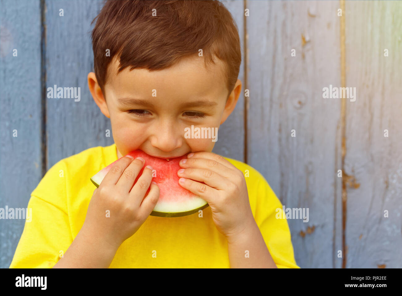 Melon d'été enfant kid little boy eating copyspace copie espace piscine en plein air à l'extérieur de mordre Banque D'Images