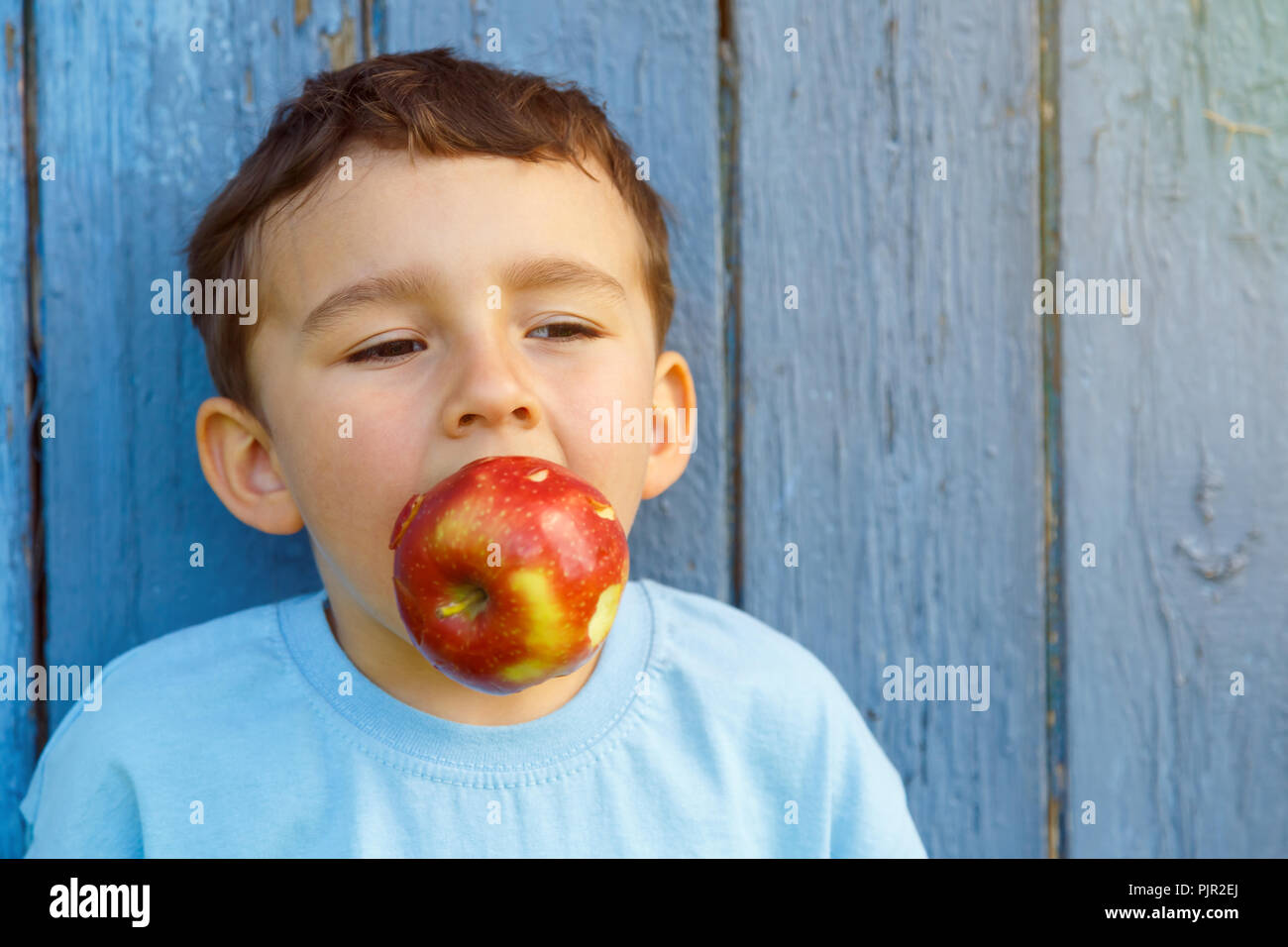 Pomme fruit biting enfant petit garçon copyspace copie espace piscine en plein air à l'extérieur Banque D'Images