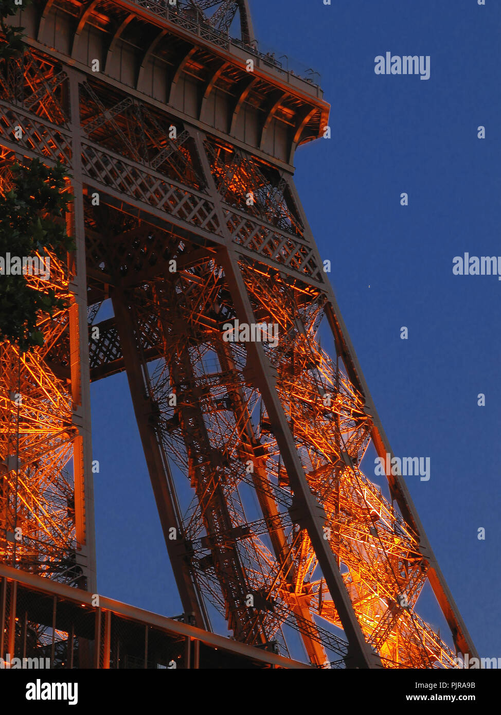 Détail de la Tour Eiffel : le pilier nord-ouest et le premier niveau, éclairé en fin de soirée : Paris, France Banque D'Images