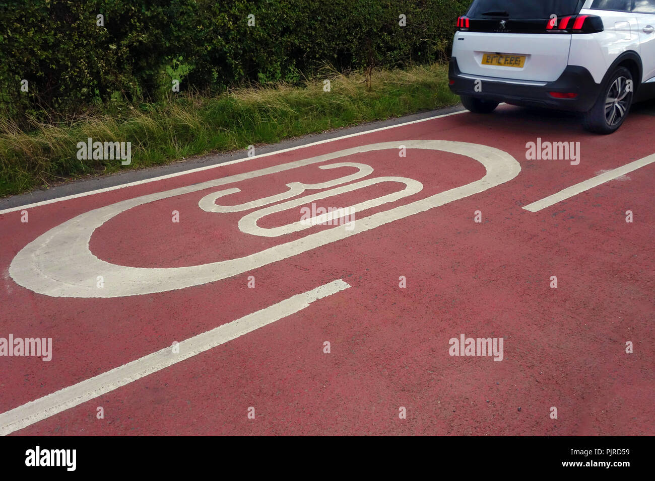 30 massive symbole sur une route couverte de rouge à 30 milles à l'heure de limite de vitesse Banque D'Images