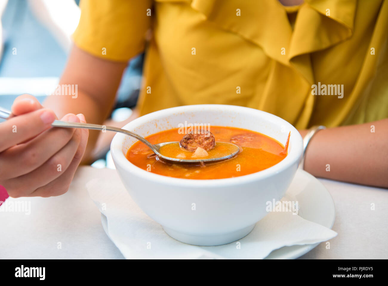 Femme mangeant la soupe hongroise avec la saucisse dans un restaurant Banque D'Images
