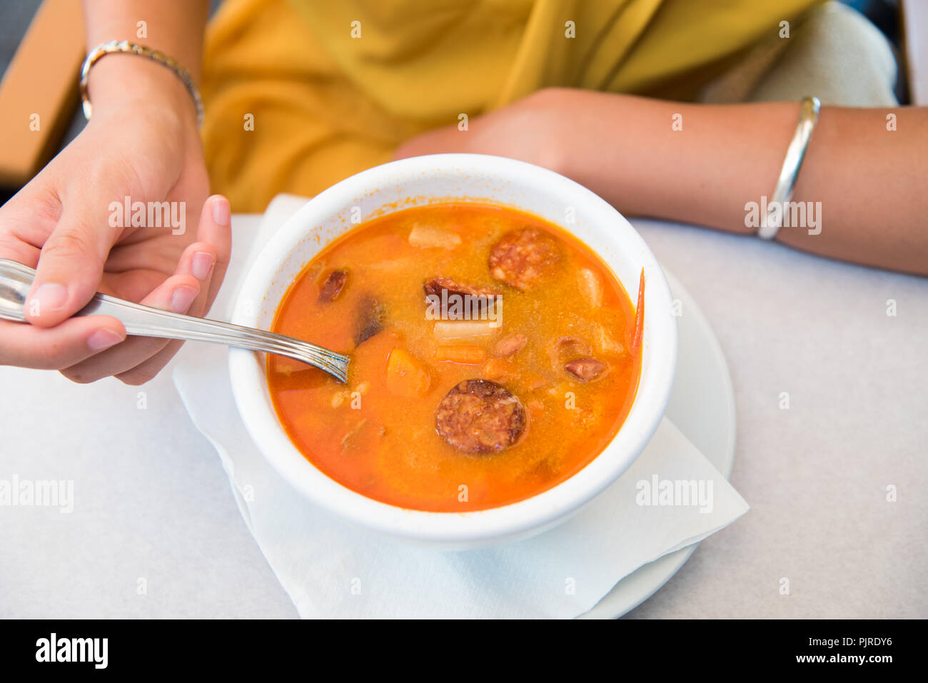 Femme mangeant la soupe hongroise avec la saucisse dans un restaurant Banque D'Images