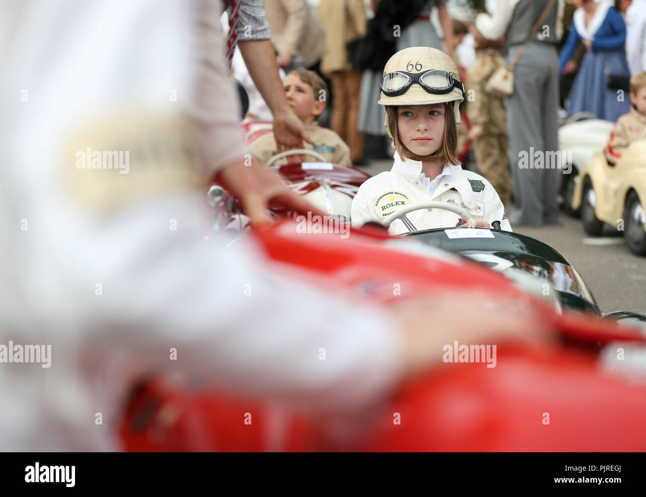 Lottie Alexander, 8 ans, de Surrey, est assis dans sa voiture à pédales Austin J40 dans la zone d'assemblage avant la coupe Settrington, le jour deux du Goodwood Revival au Goodwood Motor Circuit, dans la région de Chichester. Banque D'Images