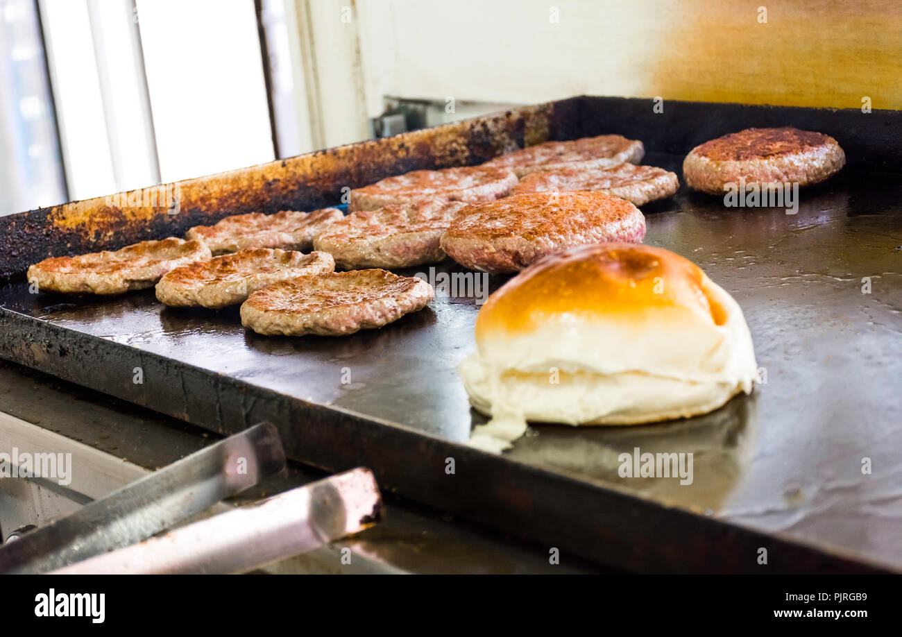 La cuisine et l'effilochage des hamburgers et des hamburgers sur le grill avec pain Banque D'Images