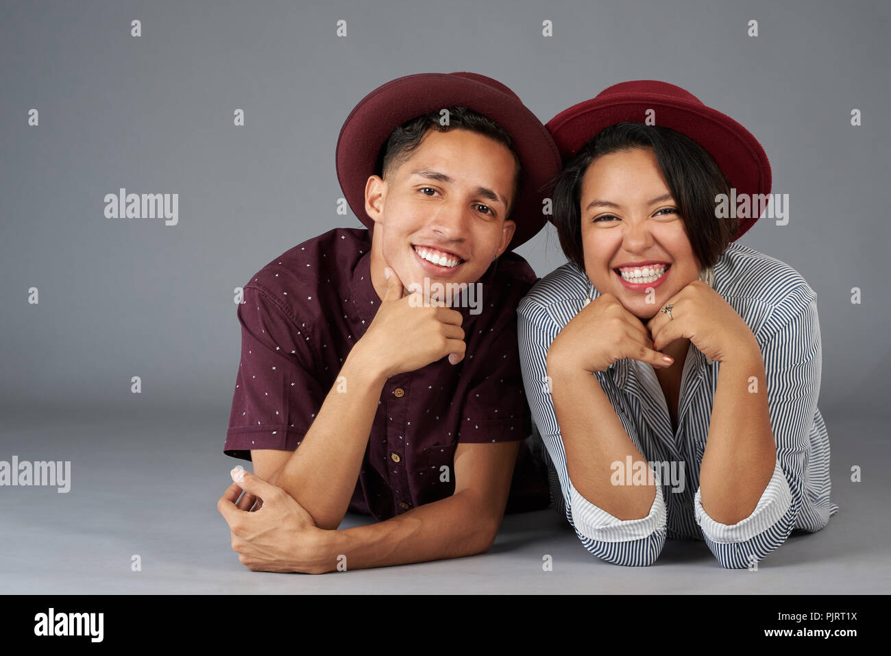 Happy smiling young couple hipster isolé sur fond gris studio Banque D'Images